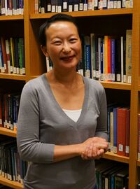 Grace Oei Associate Director photo taking in the library