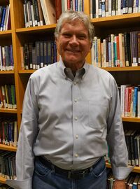 James Walters is an Assistant Professor of Ethics photo taking in the library
