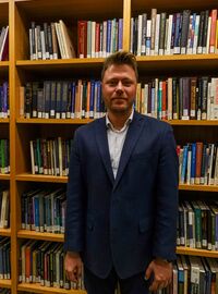Dr. Dubov is an Associate Professor of Behavioral Health and Bioethics taking a photo at the library