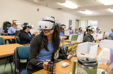 Nursing student wearing VR goggles in a classroom setting
