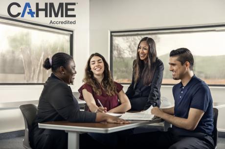 three college students and a professor sitting around a table conversing.