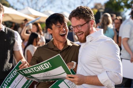 Asian man and Caucasian man outside smiling as they learned their fate at match day 2026