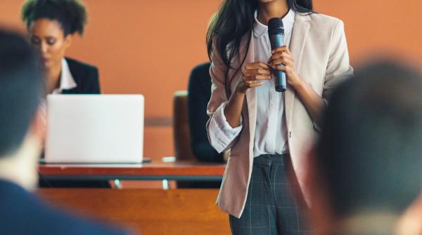 female presenter talking in front of a lecture crowd