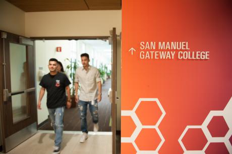 College interior signage with students walking by