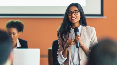 female presenter talking in front of a lecture crowd